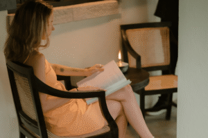 Guest sitting in a rattan chair reading a book by candlelight on a quiet porch at Beldon.