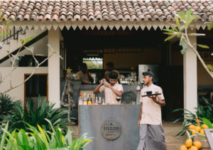 Professional bartenders mixing fresh drinks behind the rustic-chic outdoor bar counter at the Beldon Café & Restaurant.